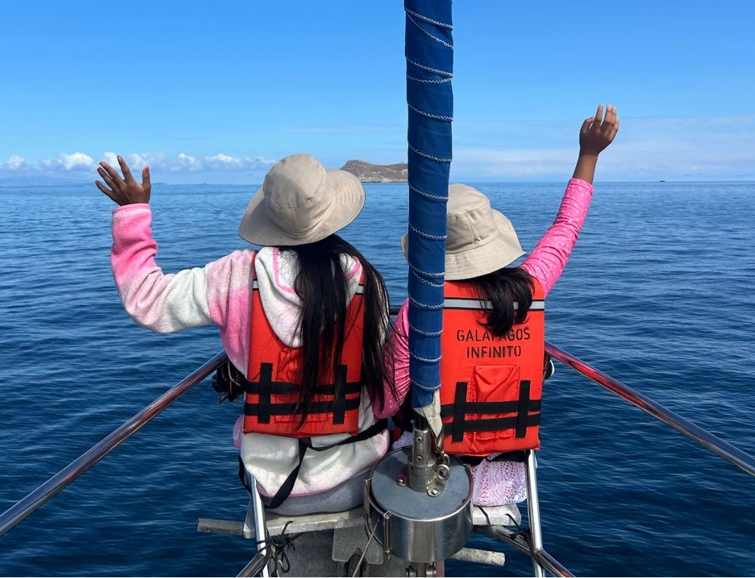 Dos niñas participantes del proyecto Aula Oceánica de espaldas en una lancha viendo hacia altamar