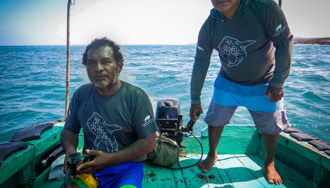 Doss hombres pescadores sobre una lancha en altamar 