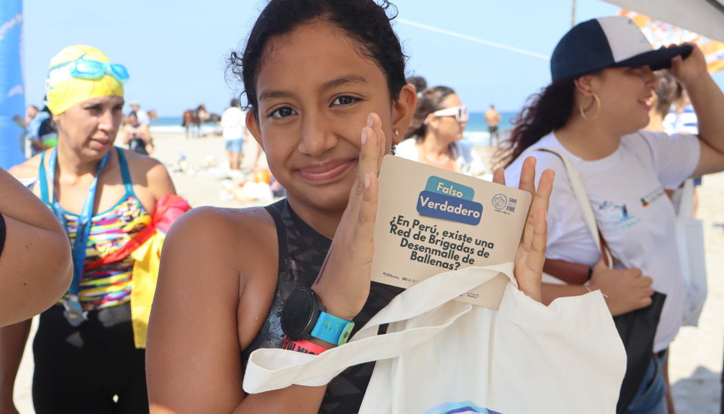 Niña con material educativo y promocional entregado durante la Travesía Máncora–Vichayito 2025 